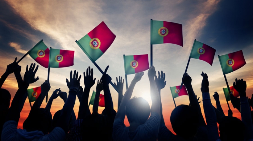 Group of People Waving Portuguese Flags in Back Lit Concept