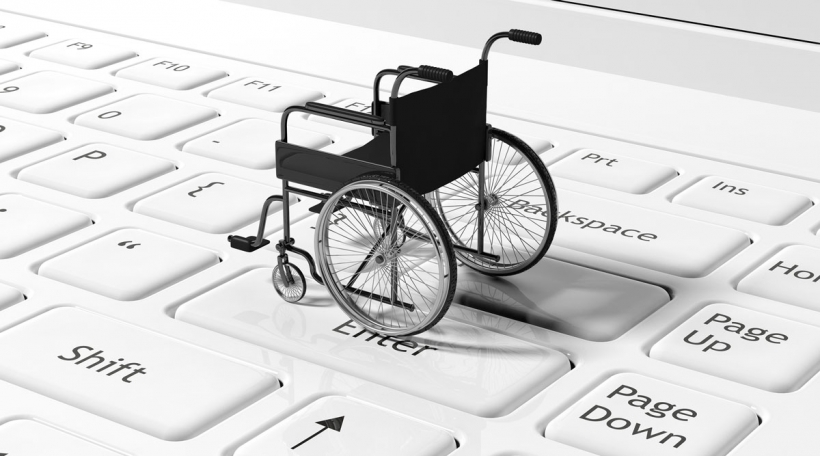 Wheelchair on black laptops keyboard, conceptual