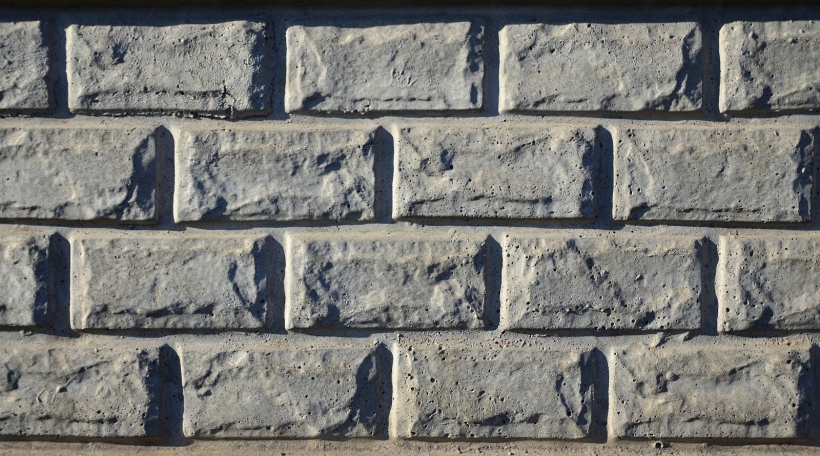 Stone fence texture - building feature. Texture of concrete fence with relief and texture like a stone wall
