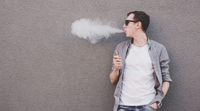 Jonke Mann fëmmt elektronesch Zigarett